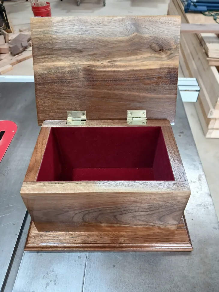 Open black walnut keepsake box with red velvet lining and brass hinges